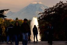Student stands in front of a fountain.