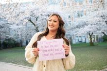 Savannah Fincher stands in front of blooming cherry trees.