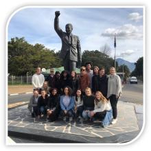 Group of students from South Africa Study Abroad program by a statue
