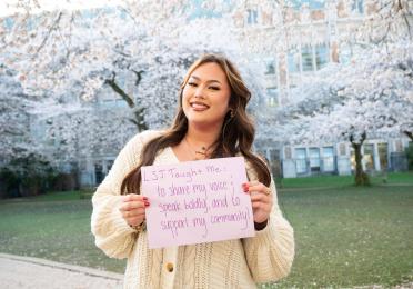 Savannah Fincher stands in front of blooming cherry trees.