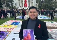 Paulo Pontemayor outside the White House, with the AIDS Memorial Quilt spread out on the lawn behind him. 